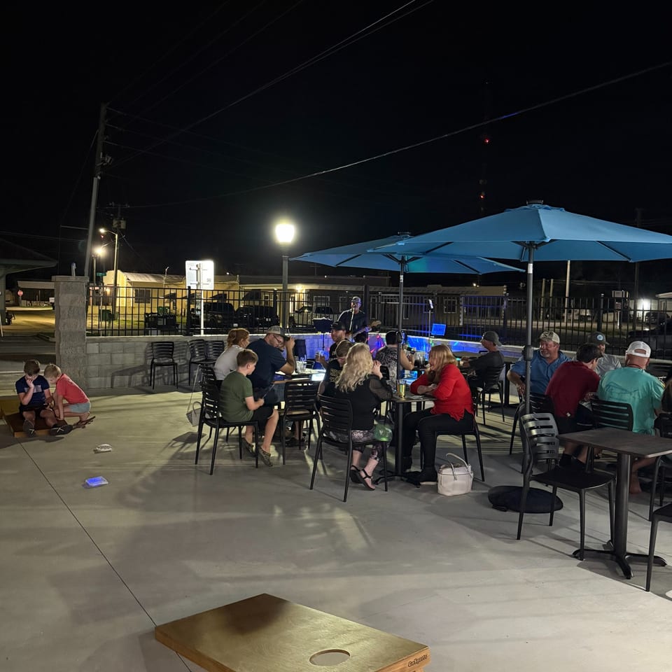 A cornhole board on the patio during an evening gathering.
