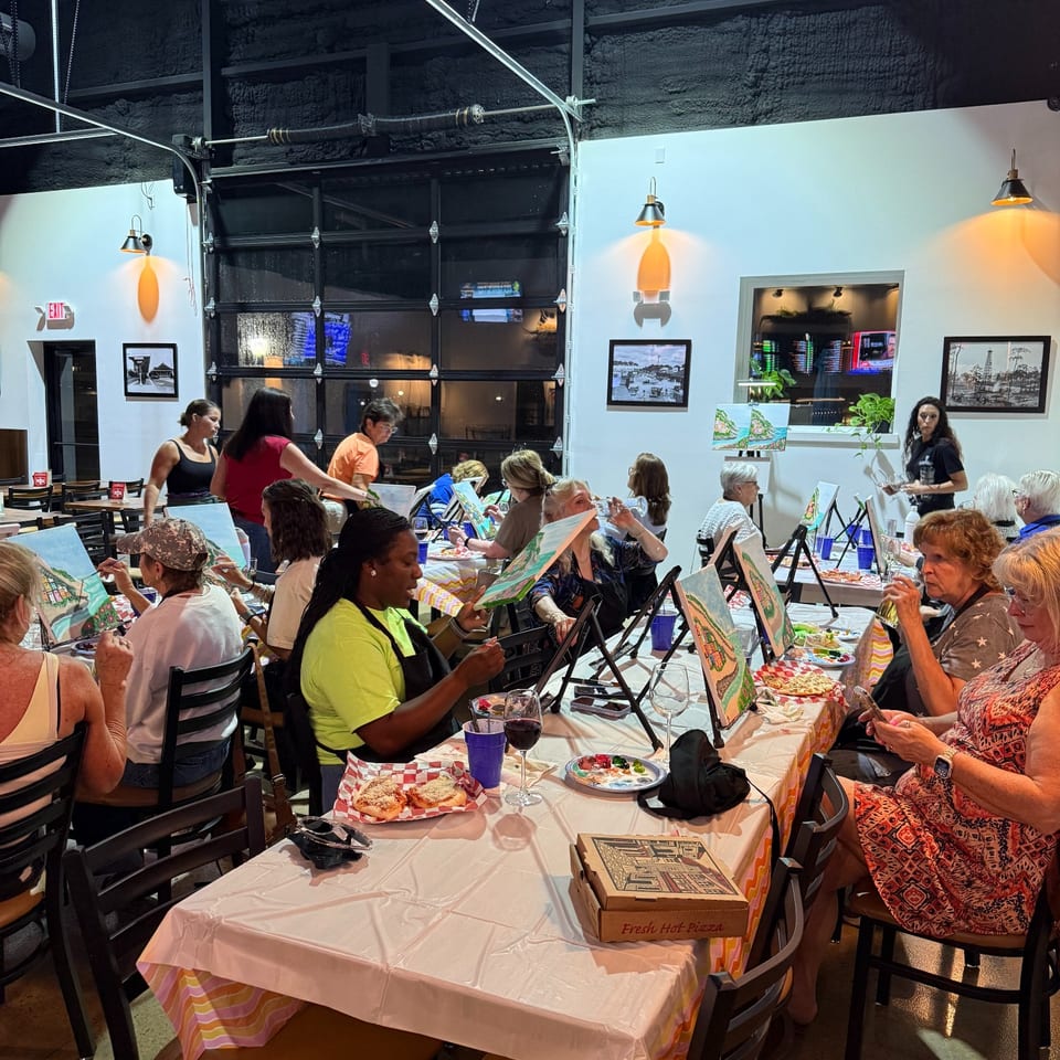 Guests painting together in Chipley Station's open-beam dining room.
