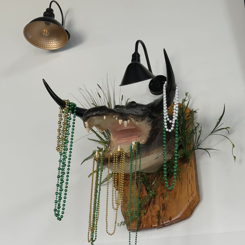 Gator wall decor draped with beads at Chipley Station.