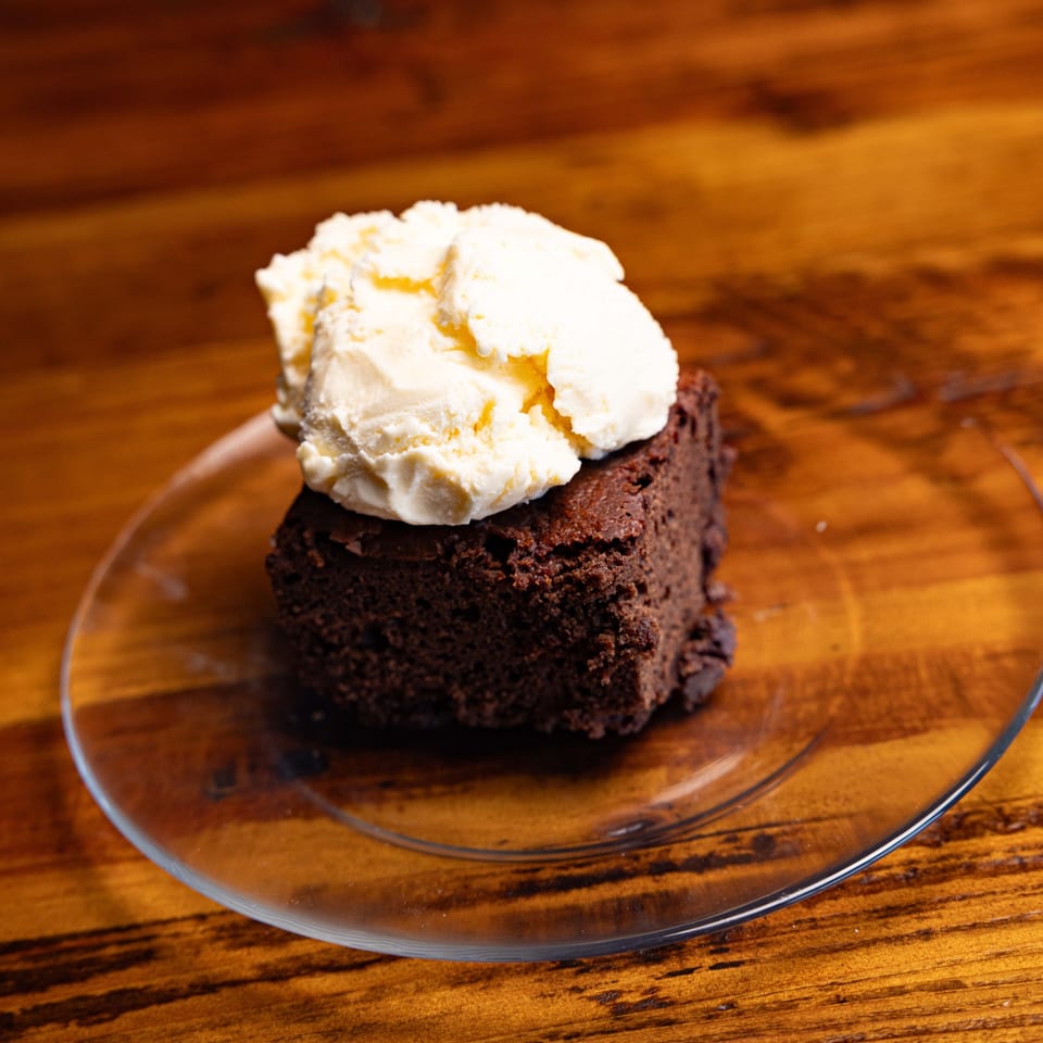 Brownie topped with ice cream.